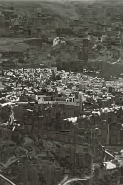 An aerial, historical view of the Fez medina skyline, capturing the city's dense labyrinth of rooftops, minarets, and winding streets. The scene reflects the grandeur of Fez untouched by modernity.