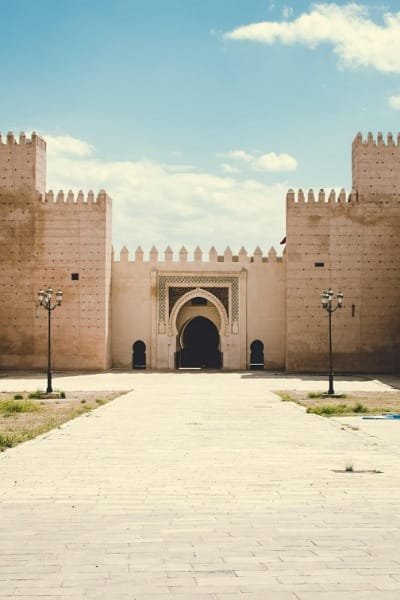 A picture of Bab Makina in Fez, showcasing its towering walls, watchtowers, and traditional Islamic architectural elements. The gate served as a crucial defense point and is a major tourist attraction.