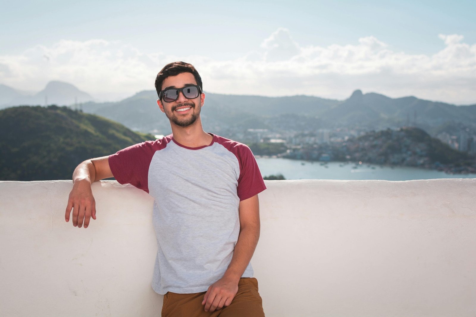 3-Day Desert Tour: From Fez to Merzouga and Ouarzazate 8 Young man in sunglasses leaning on a balcony with a scenic city view in the background.