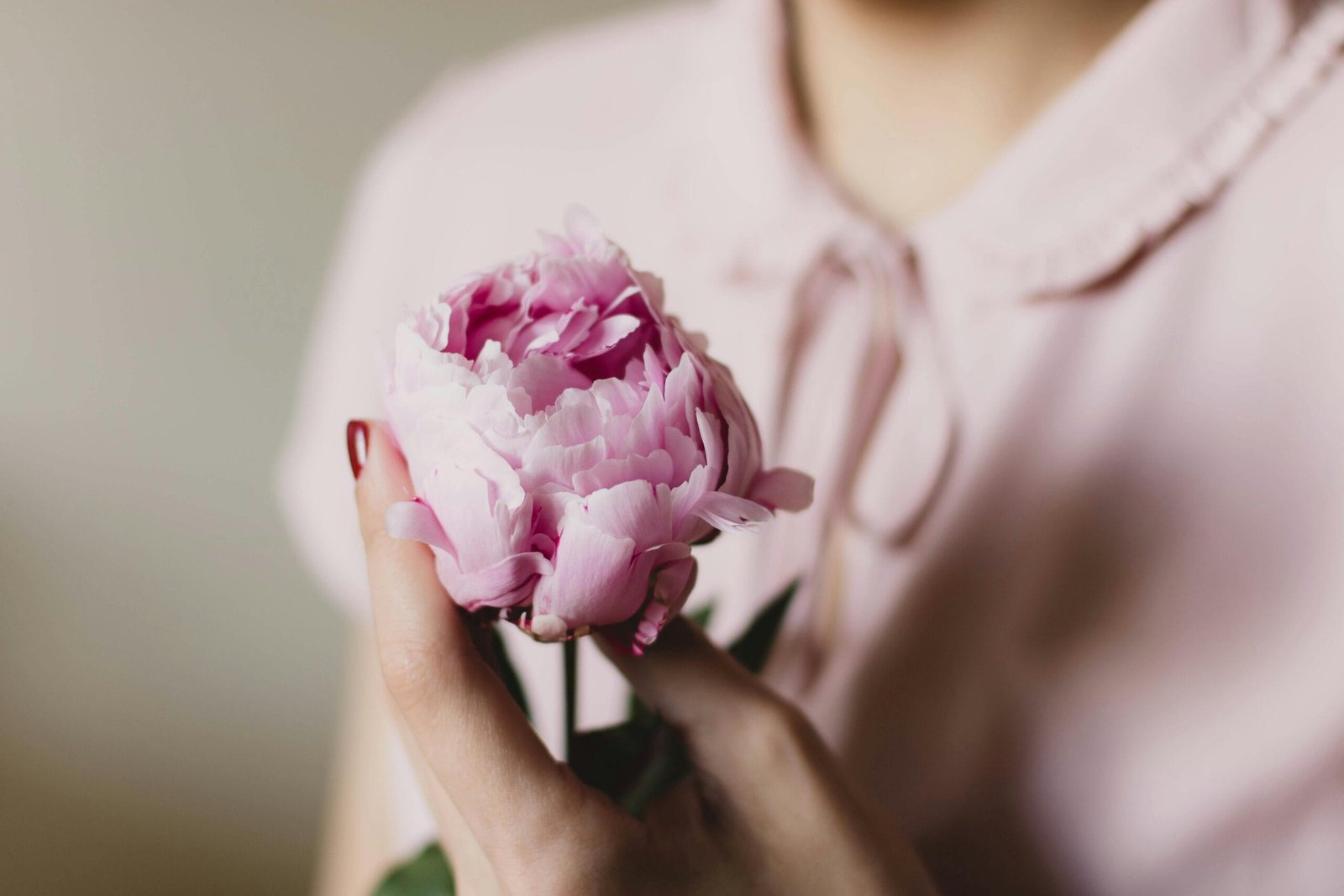 3-Day Desert Tour: From Fez to Merzouga and Ouarzazate 7 Close-up of a woman gently holding a pink peony flower, showcasing softness and elegance.
