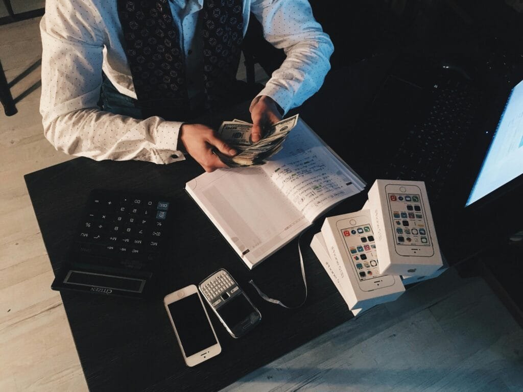 Guesthouse in the city of Fez. 27 Businessman organizing finances with tech devices and cash on desk.