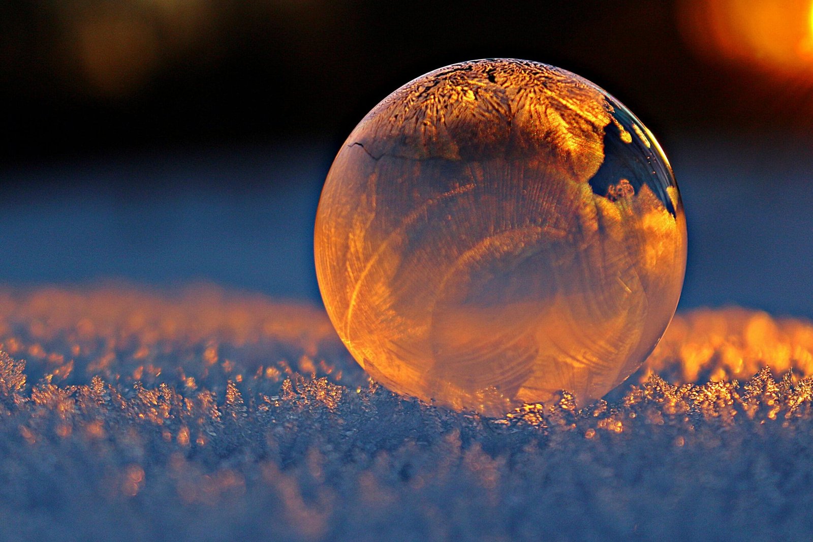 Guesthouse in the city of Fez. 28 Close-up shot of a frozen bubble with warm reflections resting on a snowy surface at twilight.