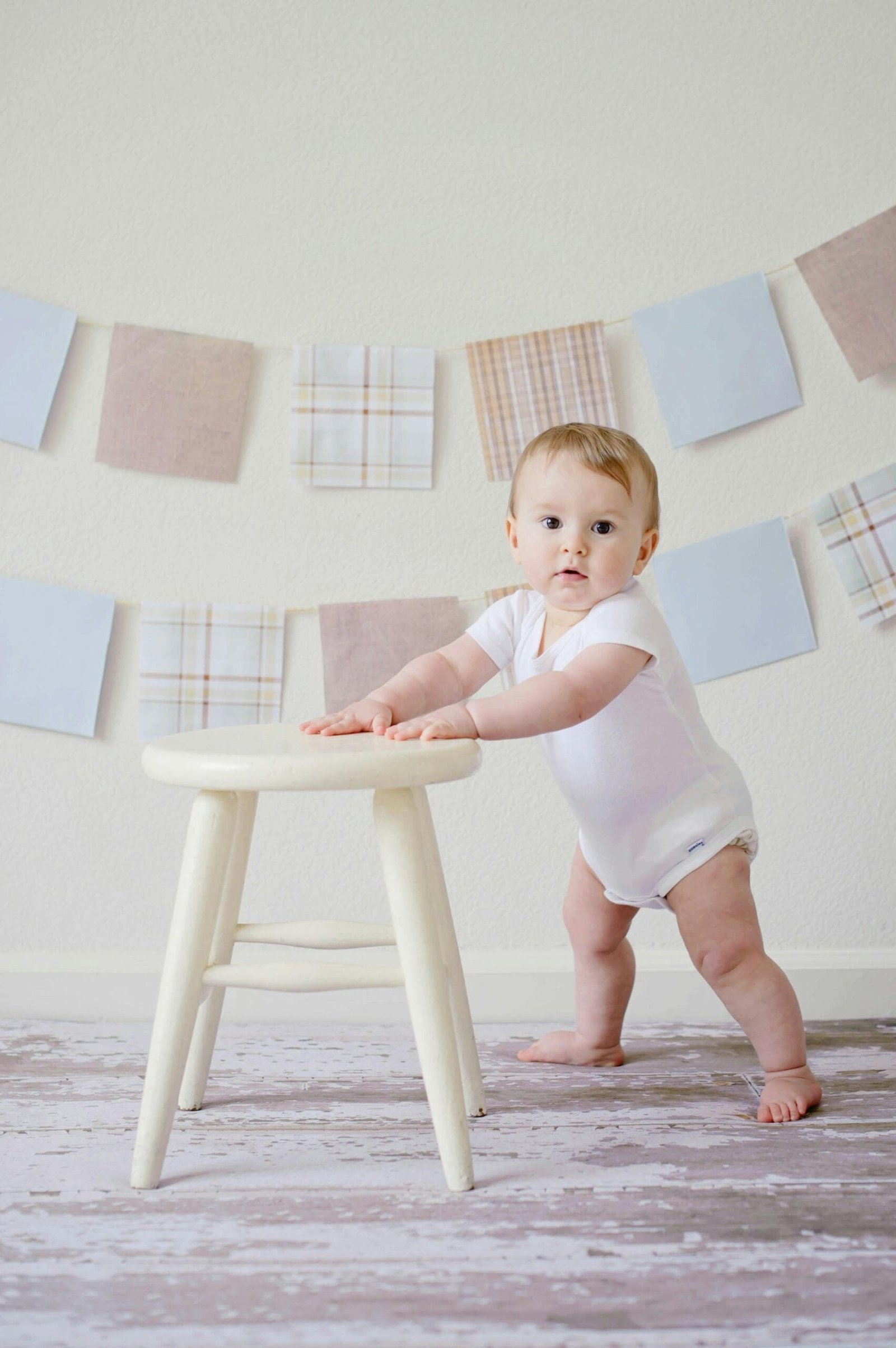 Night tours (3 to 4 hours) 5 Cute baby standing by a stool indoors with a playful background.