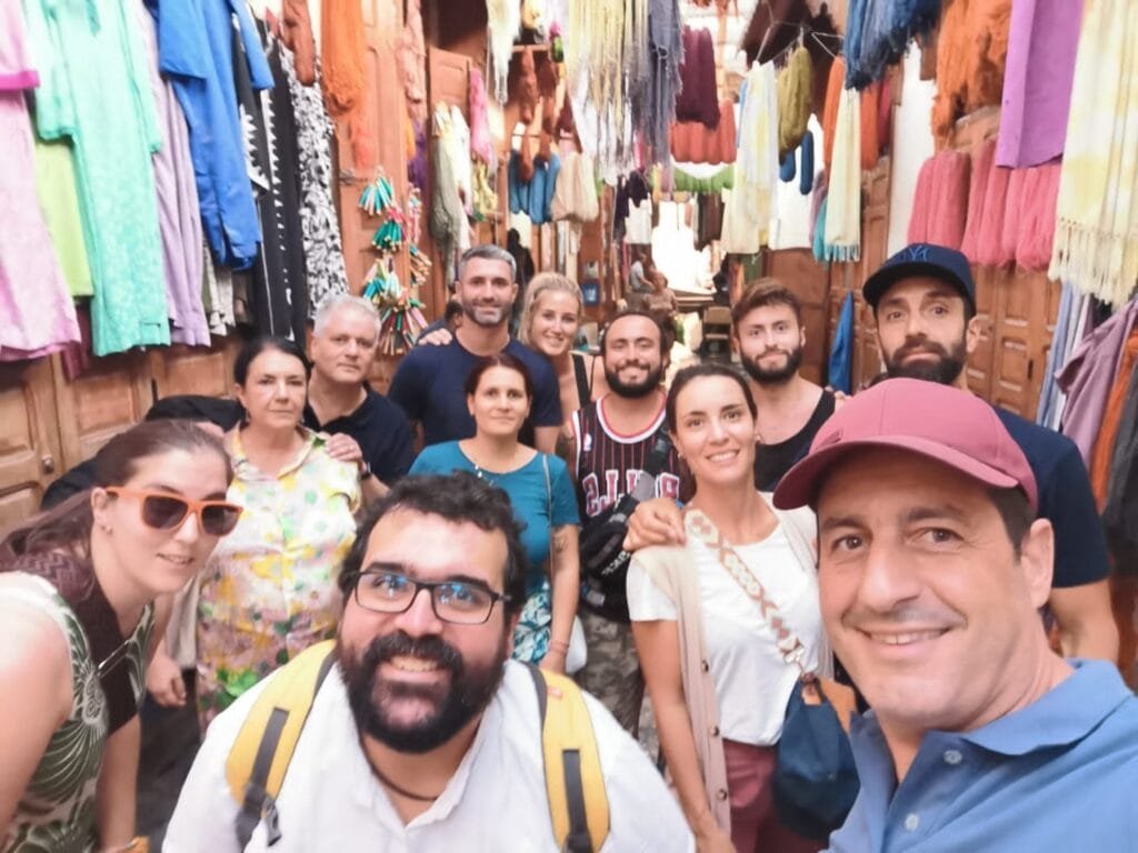 Top Things That Make Fez Special: History & Handicrafts 43 In the heart of the ancient medina of Fez, lies the Dyeing Quarter (Souk as-Sabbaghine), one of the oldest and most famous places for fabric and leather dyeing in Morocco. This traditional market is a living display of ancient craftsmanship, still practiced using the same manual techniques that have been passed down for centuries.🌈 What Will You See?
Vibrant dyeing vats where fabrics are immersed in natural dyes extracted from plants and minerals.Artisans in work attire, moving fabrics from one vat to another, creating a lively and colorful scene.Shops selling hand-dyed Moroccan textiles, such as silk, wool, and cotton, used for traditional garments like jellabas and caftans.📸 A Unique Experience:
Perfect for photography, especially from the balconies overlooking the quarter.A chance to see how dyeing was done in ancient times, long before the advent of machines and synthetic chemicals.🧭 Location:
The Dyeing Quarter is located near the Souk el-Attarine and the Al-Attarine Madrasa, easily visited during a tour of Fez’s old city.