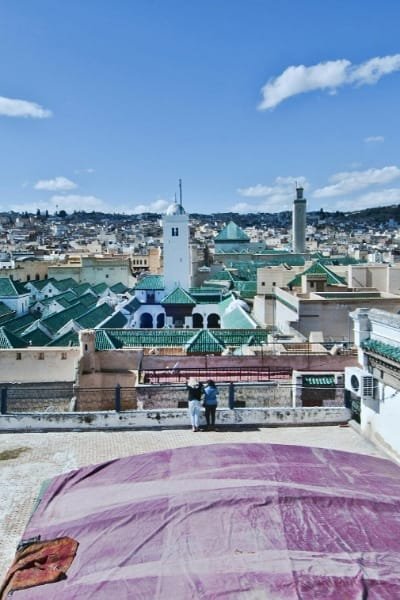 A Moroccan craftsman focusing intently on shaping metal in a workshop, symbolizing the ancient, precious handicrafts and the creatively pulsing present of Fez. This work is a crucial part of Fez's golden past and its appeal to travelers.