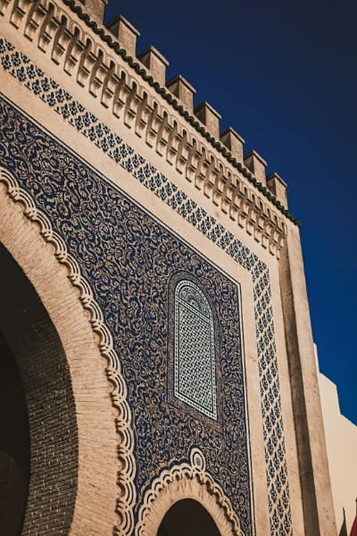 A detailed close-up of the magnificent exterior arch of Bab Boujloud (The Blue Gate) in Fez, showcasing its stunning blue and white mosaics. This iconic landmark serves as the main entrance to the old medina.