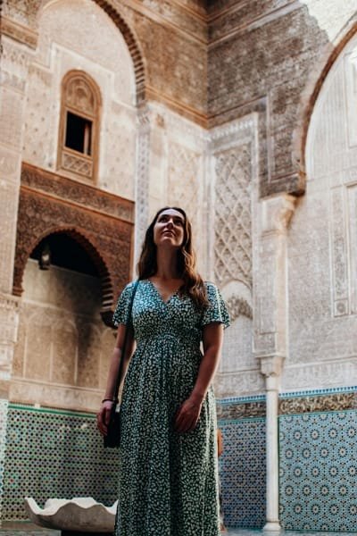 The richly decorated central courtyard of the Bou Inania Madrasa in Fez, showcasing intricate stucco work, beautifully carved cedar wood, and geometric zellige tiles. This impressive site was built in the 14th century by Sultan Abu Inan Faris.