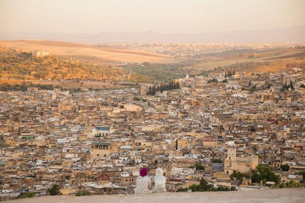 The arched entrance to a vibrant souk in the Fez Medina, capturing the essence of the city's historical architecture and bustling daily life. This image serves as the perfect visual for a comprehensive guide to visiting Fez (What to See, Where to Eat, Where to Stay).