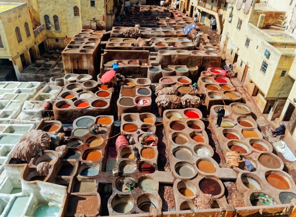 Why Is Fez, Morocco, Famous? 25 No visit to Fes is truly complete without immersing yourself in the iconic experience of the Chouara Tannery — the oldest and most renowned tannery in the city. Here, for over a thousand years, leather has been crafted using traditional methods passed down through generations, techniques that have remained remarkably unchanged by the passage of time. From the vantage points of the terraces above, you'll be captivated by a vibrant panoramic scene, akin to a living mosaic of colorful dye pits. Skilled artisans work diligently below, their hands expertly transforming raw hides into the finest Moroccan leather goods, celebrated for their quality and craftsmanship. Visiting the Chouara Tannery is a holistic sensory experience: the rich, earthy colors that saturate the landscape, the palpable scent of history that permeates the air, and the sheer authenticity that emanates from every action of the craftsmen all come alive before your very eyes. You'll witness the various stages of leather tanning, from the initial cleaning and treatment to the vibrant dyeing and careful drying processes, gaining a profound appreciation for the effort and skill inherent in this traditional handcraft. This is a rare opportunity to delve into one of Fes's most ancient and cherished traditions, offering you an unparalleled glimpse into the city's proud artisanal heritage. Moreover, it presents the perfect chance to acquire a unique, handmade souvenir, a tangible piece of Fes's history and artistic soul that you can take home with you. Be sure to allocate ample time to explore this vital landmark that vividly embodies the spirit of Fes's craftsmanship.