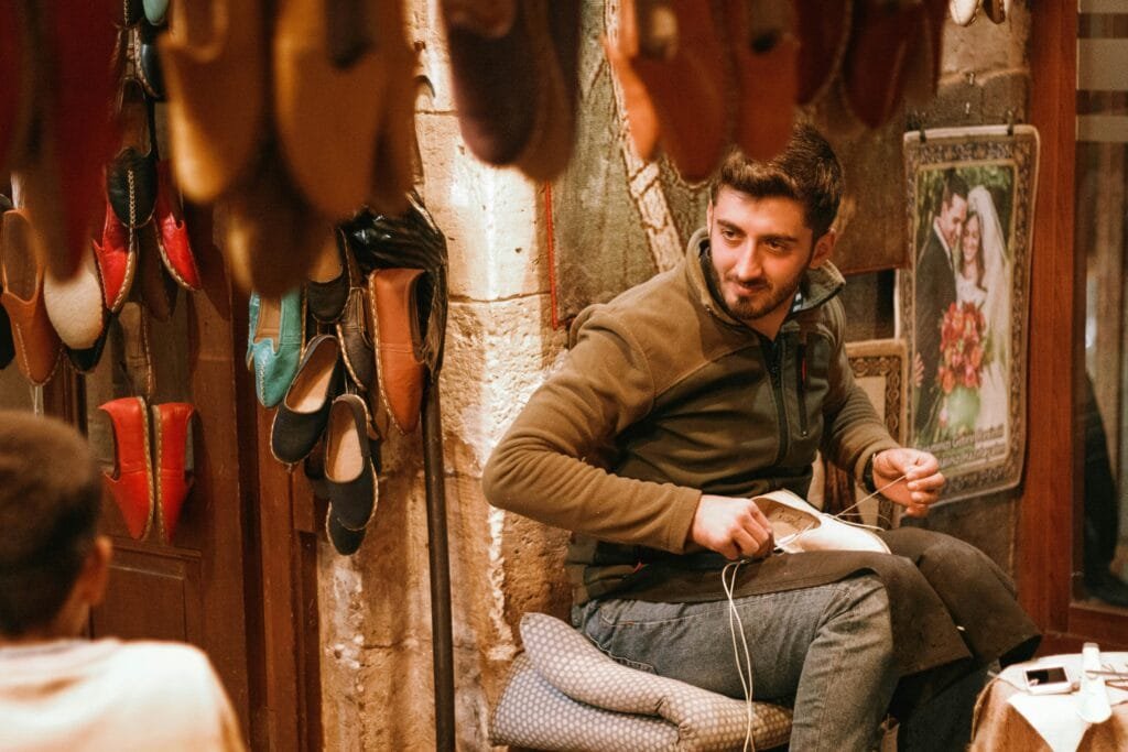 Top Things That Make Fez Special: History & Handicrafts 102 In Fez, cobblers (known as Khraaz) are artisans dedicated to creating some of Morocco's most iconic footwear: balgha (traditional slippers) and charbil (leather sandals). These skilled artisans use high-quality leather and handcrafting techniques passed down through generations to create footwear that is both functional and elegant.👢 What You’ll Find:
Balgha: Soft, handmade slippers traditionally worn by both men and women. They are crafted with care and attention to detail, often in bright, vibrant colors and decorated with intricate stitching.Charbil: A type of leather sandal that is lightweight and perfect for the warm Moroccan climate. Known for its comfort and durability, the charbil is a staple of Moroccan footwear.🛍️ Where to Buy:
These traditional footwear items can be found in the Qasaria al-Kifah (Casería al-Kifah) in Chellah Square, where Khraaz artisans gather to showcase their creations. This market is the ideal spot to discover handmade leather goods, and you’ll find a variety of colors, sizes, and styles to suit any taste.🌟 Why It’s Worth Visiting:
Authentic Craftsmanship: Every pair of shoes is made by hand with care and precision, ensuring you’re purchasing something truly unique.Cultural Experience: The balgha and charbil represent a part of Moroccan tradition that has stood the test of time, connecting you to the rich history of the country.Sustainability and Longevity: These shoes are crafted from natural materials, making them both durable and eco-friendly. They age beautifully, creating a patina with time.Tip for visitors: Visit the Khraaz workshops in Qasaria al-Kifah to watch how these artisans transform raw leather into beautiful handcrafted footwear and even try on a pair for yourself. It's a perfect souvenir that combines craftsmanship and style.