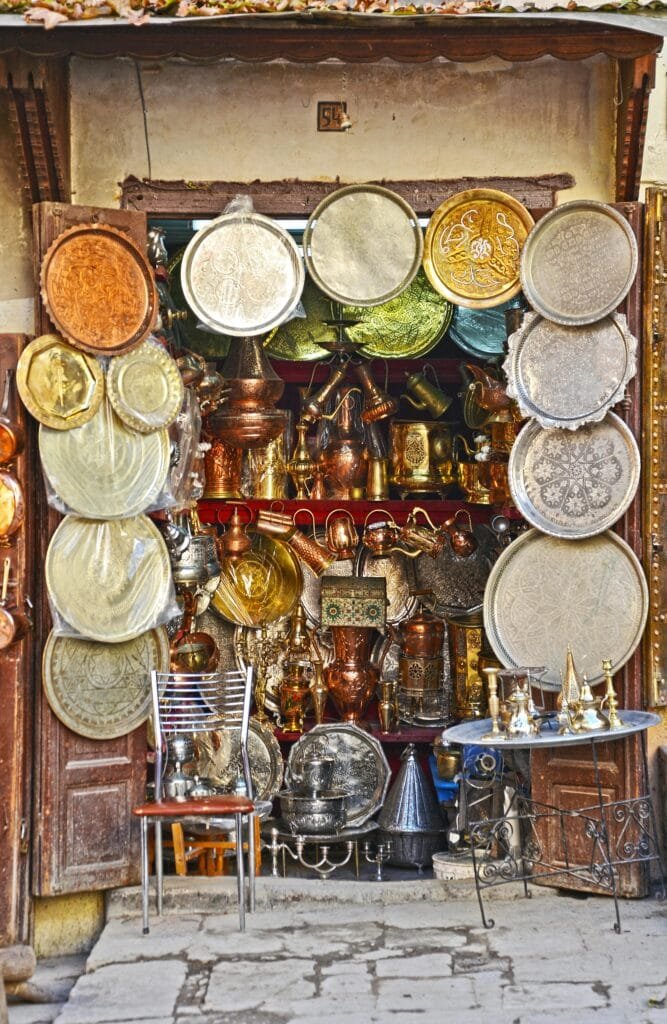 Why Is Fez, Morocco, Famous? 16 Among the narrow alleys of Fez, especially near Nejjarine Square, you’ll hear the rhythmic sounds of metal being shaped by hand. This is the world of brass and copper engraving, a centuries-old craft kept alive by dedicated artisans who turn raw metal into functional art. Using hammers, chisels, and years of experience, these craftsmen create intricate designs on trays, teapots, lamps, and decorative pieces. Each object is engraved entirely by hand, often inspired by traditional geometric or floral Moroccan motifs. 🛠 Why It’s Special: Precision & Patience: Every detail is manually carved, requiring a deep understanding of rhythm and pressure. Cultural Value: These items are not just souvenirs — they are living pieces of Morocco’s heritage and identity. Timeless Beauty: Copper and brass pieces from Fez are admired both locally and internationally for their craftsmanship and elegance. Watching these artisans work is like observing a delicate dance between strength and precision — a living tradition that gives voice to metal through beauty and skill.