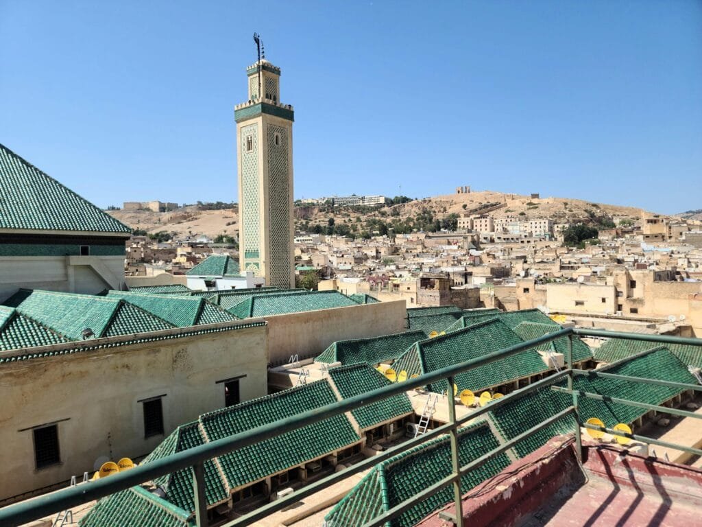 Top Things That Make Fez Special: History & Handicrafts 36 Tucked away in the heart of the Fez medina, the Mosque of the Andalusians (also known as Andalusian Mosque) is one of Morocco’s oldest and most beautiful mosques. Founded around 859 CE by Maryam al-Fihri, sister of the founder of the Qarawiyyin Mosque, it stands as a spiritual and cultural twin to its more famous neighbor.🌟 Highlights for Travelers
Andalusian Heritage: Built by refugees from Islamic Spain, the mosque showcases the elegant fusion of Andalusian and Moroccan architectural traditions.Architectural Beauty: Admire the horseshoe arches, intricate stucco work, and the finely carved wooden minbar (pulpit) visible from the courtyard.Scenic Setting: Although non-Muslim visitors cannot enter the prayer hall, the façade, outer courtyard, and riverside ambiance offer a profoundly atmospheric experience—especially at sunset.📍 Where to Find It
Neighborhood: Andalusis Quarter, directly across the Fez River from the University of al-Qarawiyyin.Directions: Easily included in any walking tour of the medina; ask a local guide or follow signs toward “Andaloussiyn.”Visiting the Mosque of the Andalusians enriches your journey through Fez with a taste of its Andalusian roots and a moment of serene beauty by the water’s edge.