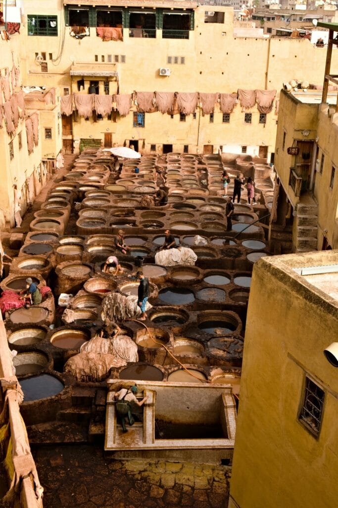 Top Things That Make Fez Special: History & Handicrafts 64 One of the most iconic and unforgettable experiences in Fez is visiting the Chouara Tanneries, the largest and oldest leather tanneries in Morocco — and possibly the world. This ancient craft has been practiced in Fez for over a thousand years, making the city a historic capital of leather production and trade.As you arrive, you'll witness vats filled with colorful natural dyes, where skilled workers treat and dye hides using traditional, centuries-old methods. The strong smells and vivid colors are part of the authentic atmosphere that makes this experience truly unique.🧳 Why It’s Worth Visiting:
Living Heritage: These tanneries are not a museum — they are fully functional and alive with daily work.Handmade Quality: The leather produced here is still used to craft high-quality bags, slippers (babouches), belts, and more — many of which are exported worldwide.Cultural Insight: Visiting the tanneries gives you a deeper understanding of Fez’s artisanal soul and its importance in global trade routes of the past.