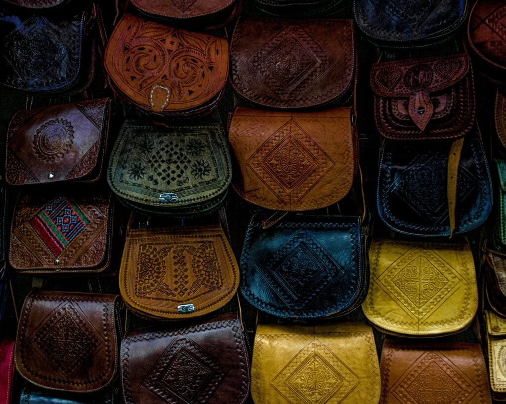 Top Things That Make Fez Special: History & Handicrafts 99 Fez is renowned for its leather craftsmanship, and its skilled artisans are masters in transforming raw hides into beautifully crafted leather goods. The leatherworkers in Fez have been perfecting their techniques for centuries, and their creations are synonymous with quality, style, and tradition.👝 What You’ll Find:
Handcrafted Handbags
These artisans create exquisite leather handbags that blend traditional designs with modern sensibilities. Each piece is carefully sewn by hand, using top-quality leather that becomes more beautiful with age.Backpacks and Travel Bags
Known for their durability and elegance, the leather backpacks and travel bags crafted by these artisans are not only functional but also stylish, making them perfect for travelers seeking something both practical and sophisticated.Custom Leather Goods
From belts to wallets and shoes, the leatherworkers in Fez are capable of creating personalized items to suit any taste, making these items perfect souvenirs for visitors looking for something unique and special.🌟 Why It’s Worth Visiting:
Handmade Quality: Every leather item is made to last, with attention to every detail, from stitching to finishing.Cultural Connection: Purchasing from these artisans allows you to take home a piece of Fez’s rich heritage, while supporting local craftsmanship.A Timeless Investment: Leather products from Fez are known for their longevity and patina, and their quality ensures they only improve with time.