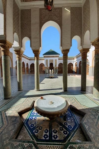 The tranquil courtyard of Al-Andalus Mosque in Fez, showcasing elegant arches, Zellige flooring, and intricately carved stucco walls. The mosque is a symbol of Andalusian-Moroccan heritage, founded in the 9th century, and features stunning Islamic architecture.