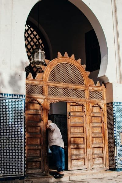 The richly decorated wooden entrance of Al-Qarawiyyin Library or a similar madrasa in Fez. Founded in the 9th century, this institution is the oldest continuously operating library in the world, renowned for its stunning Andalusian architecture and preservation of rare manuscripts.