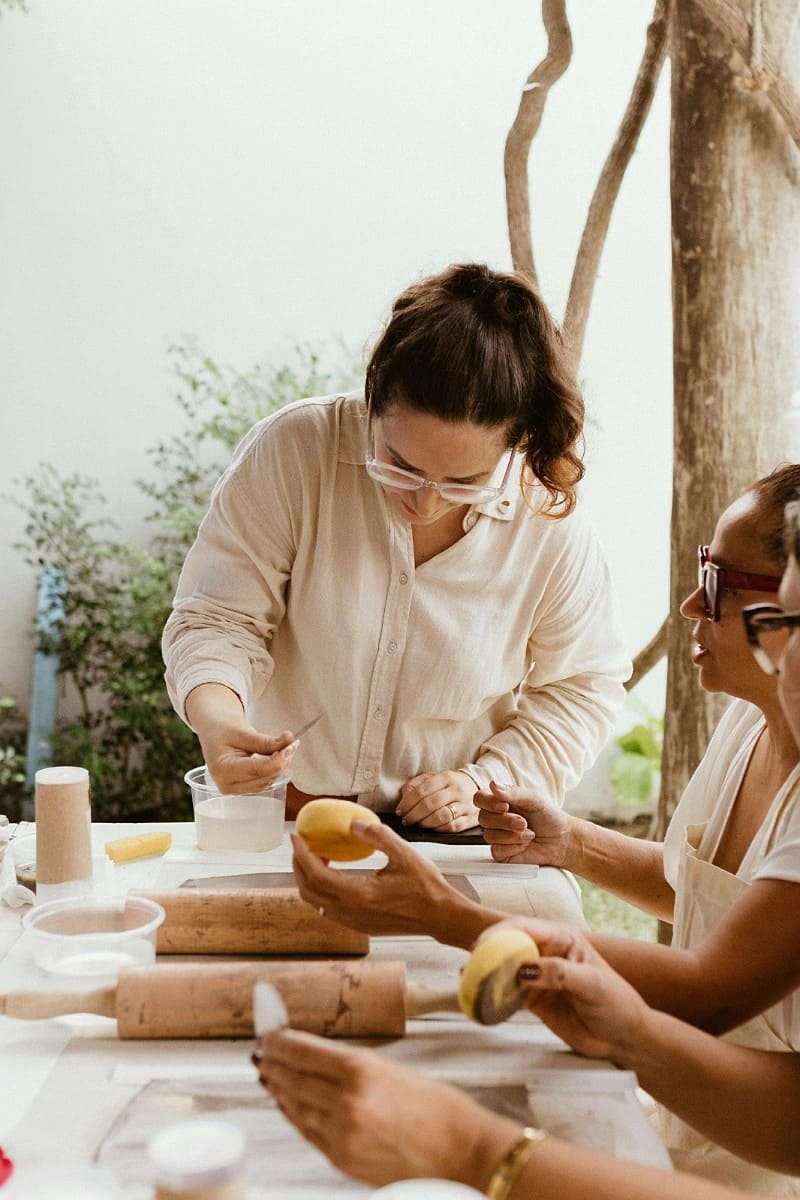 Women learning traditional Moroccan cooking in a relaxed outdoor workshop.