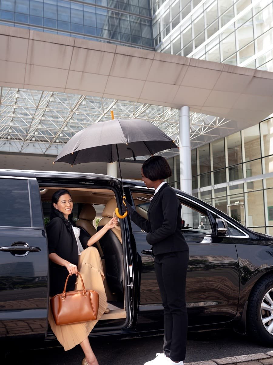 Fes private transfer service: Professional driver assisting a traveler into a luxury minivan for comfortable transport in Morocco.