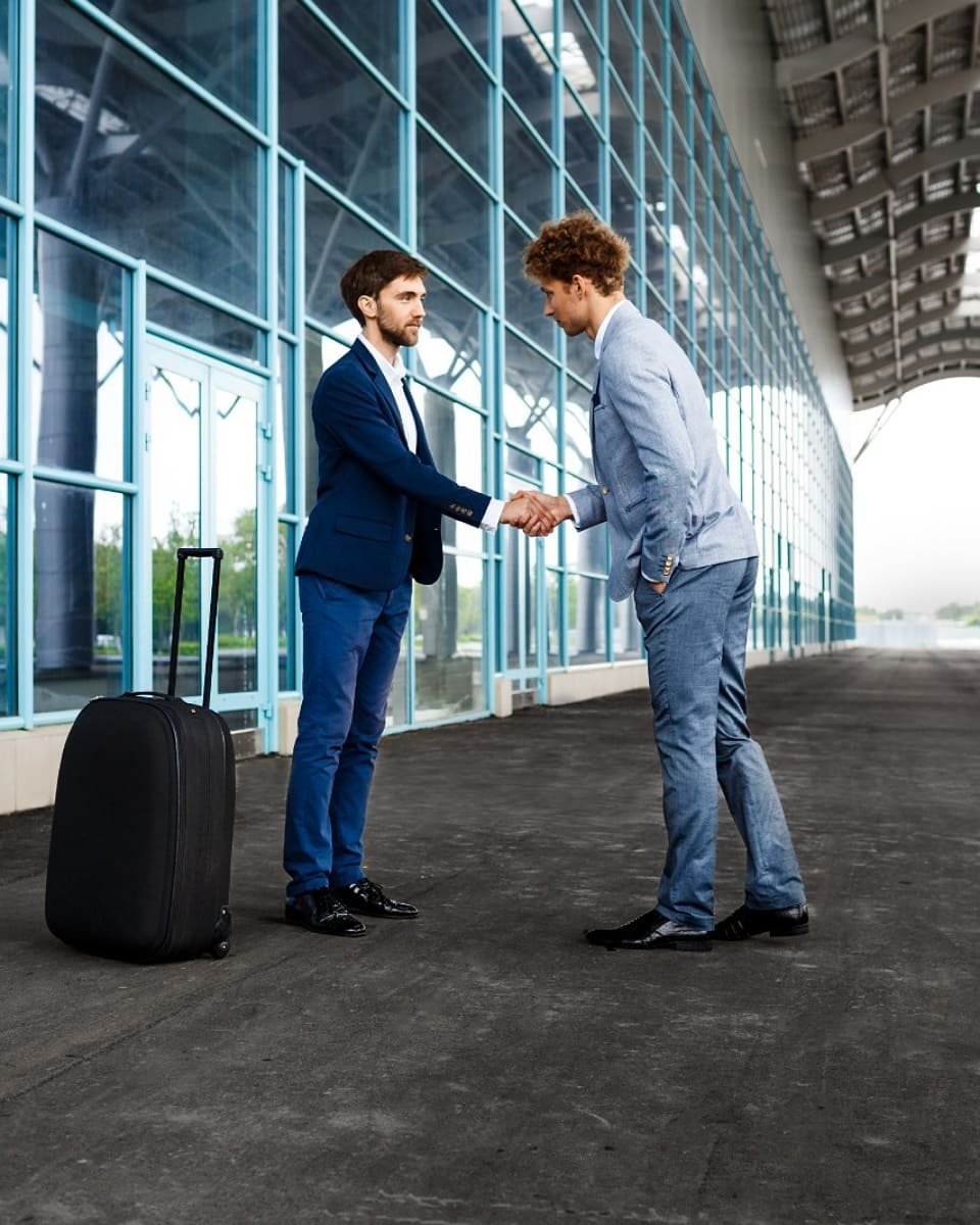 Professional private driver shaking hands with an arriving passenger at Fes airport, highlighting a reliable and welcoming airport transfer service for visitors to Morocco.