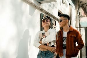 A happy male passenger smiling while talking on a mobile phone in the back seat of a clean, comfortable private car, reflecting smooth transportation service during the day trip to Chefchaouen.
