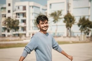 A tourist stands with arms raised facing the sunset over a wide field, symbolizing the fantastic, confident, and highly recommended experience of a Fes and surroundings tour.