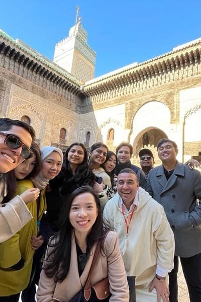 A collage of happy tourists and professional local guides taking selfies inside the Fes Medina, showcasing the social, fun, and hassle-free 5-6 hour group tour experience.