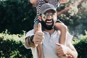 A professional Fes guide (Abdul or Mohammed) smiling warmly with a group of tourists in an ornate historical courtyard, reflecting the kind and highly knowledgeable service praised in the testimonial.