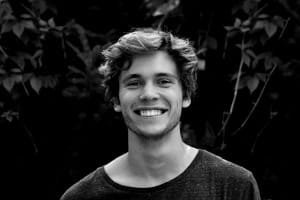 A large group of tourists smiling brightly with their Fes guide in a traditional courtyard, reflecting the warm, welcoming atmosphere and friendly service of the highly-rated cooking class.