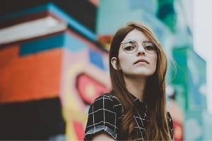 A confident female traveler/digital nomad, representing a guest who found LA CASA DAR RAYAN to have fast WiFi, a very flexible host (Hamza), and an excellent location close to the main streets in Fes Medina for remote work.