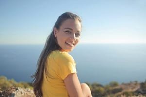 A highly knowledgeable and patient local guide accompanying a tourist couple inside an intricately decorated madrasa or mosque in Fes. The guide is recommended for his deep knowledge of Morocco's history and patience during shopping stops.